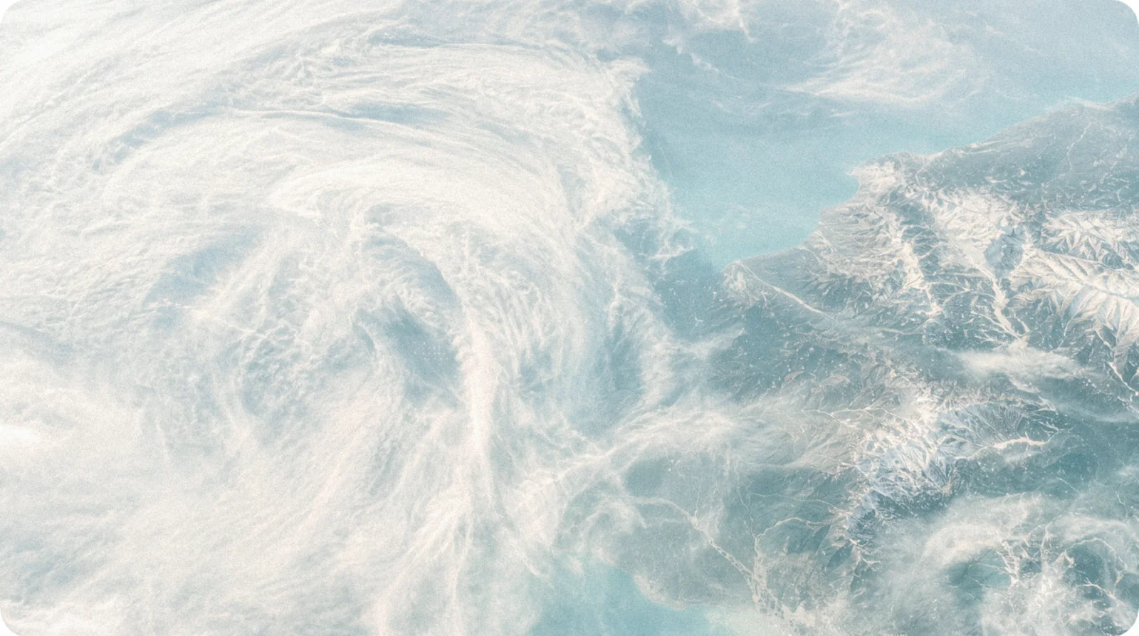 Satellitenbild von Wettersystemen, die über eine Küstenlinie ziehen.